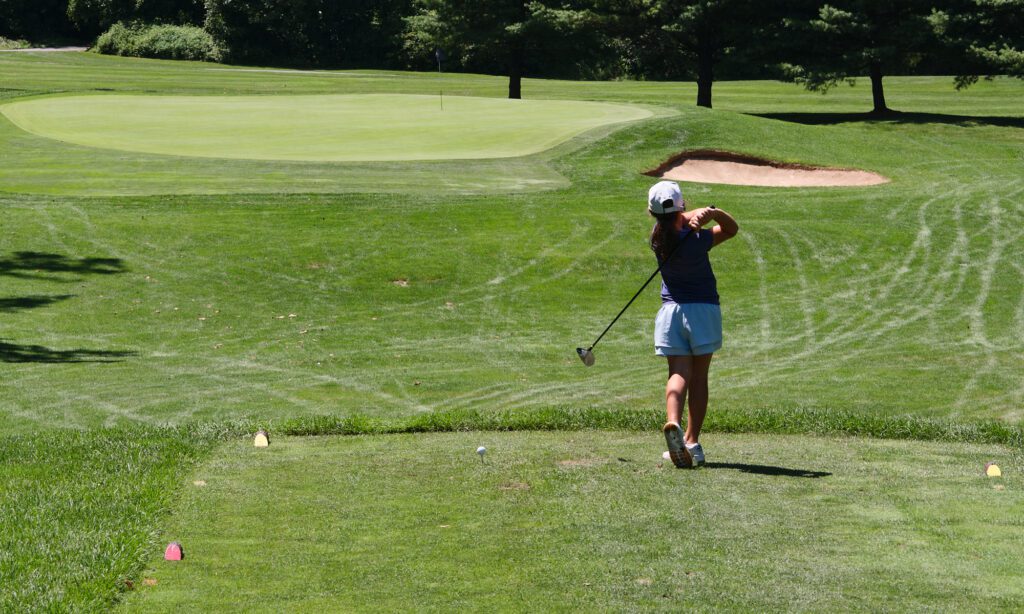 young lady tee'ing off